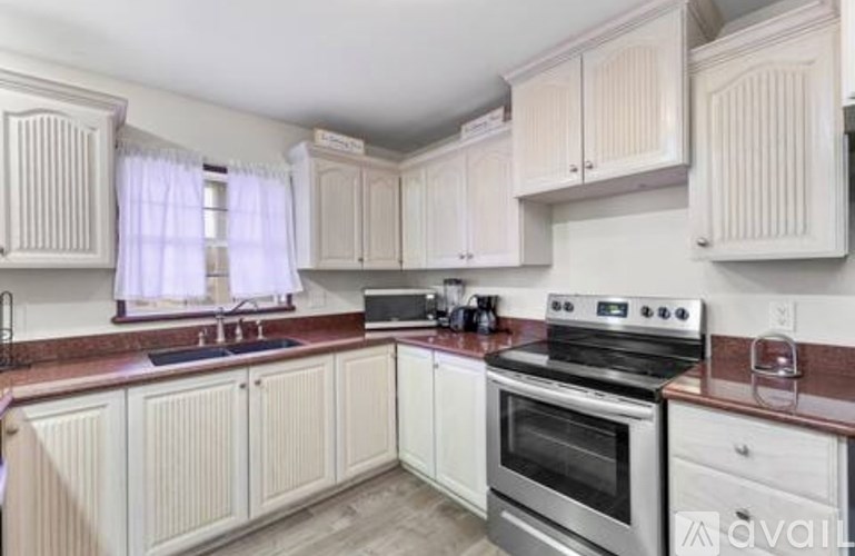 A kitchen with white cabinets and a stainless steel oven.