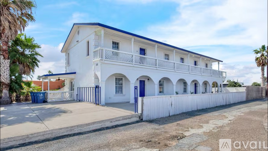 A white two-story building with blue trim and doors.