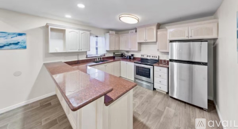 A kitchen with a marble countertop and stainless steel appliances.