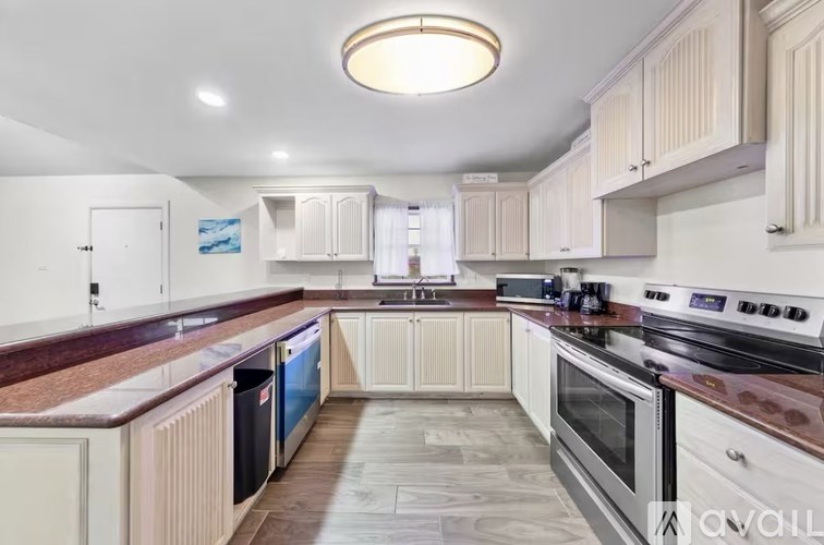 A kitchen with white cabinets and a marble countertop.