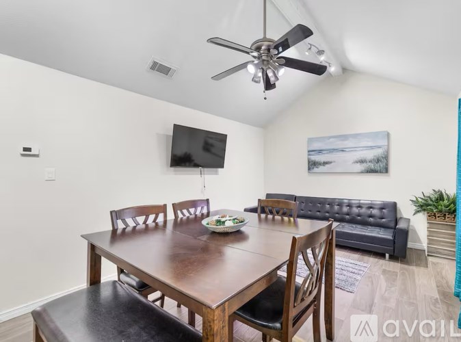 A dining room with a wooden table and chairs.