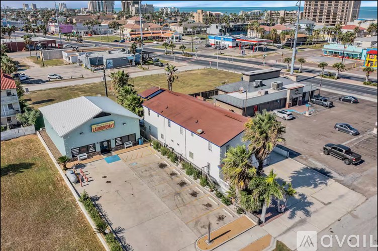 A building with a red roof is surrounded by a parking lot.