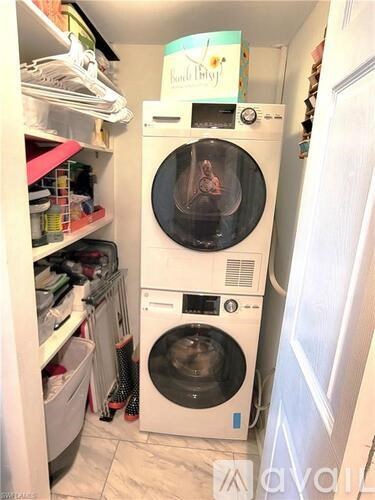 A small laundry room with a washer and dryer stacked on top of each other.