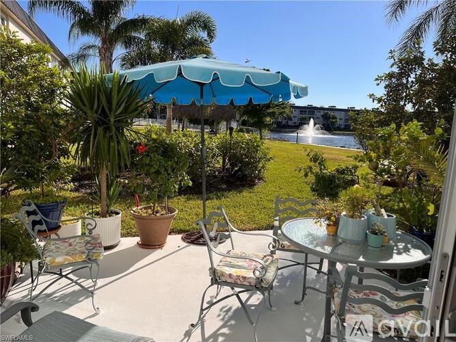 A patio with a table and chairs under a blue umbrella.