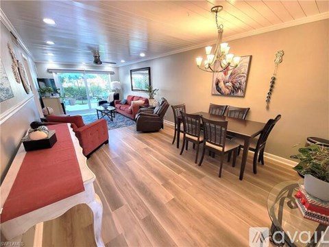 A living room with a red couch and a glass table.