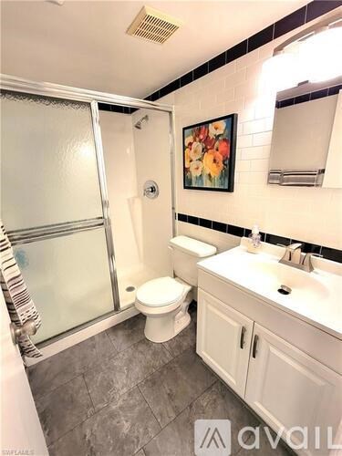 A bathroom with a toilet, sink, and shower.