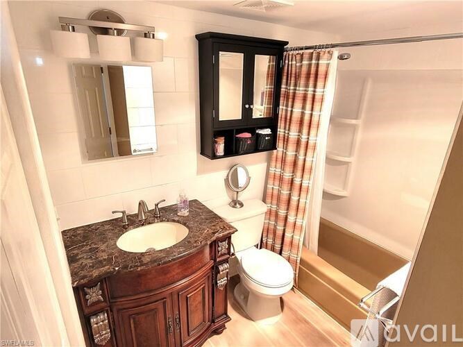 A bathroom with a sink, mirror, toilet and shower.