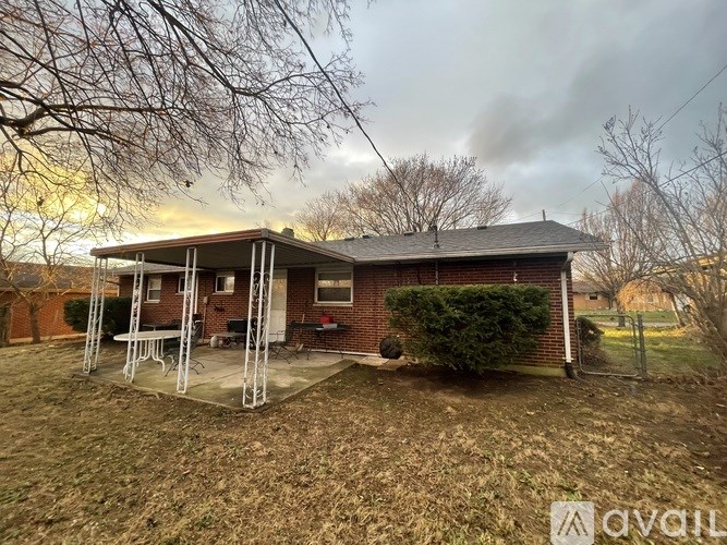 A house with a patio and a tree in front.