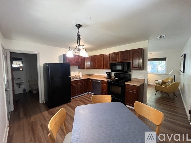 A kitchen with wooden cabinets and a black refrigerator.