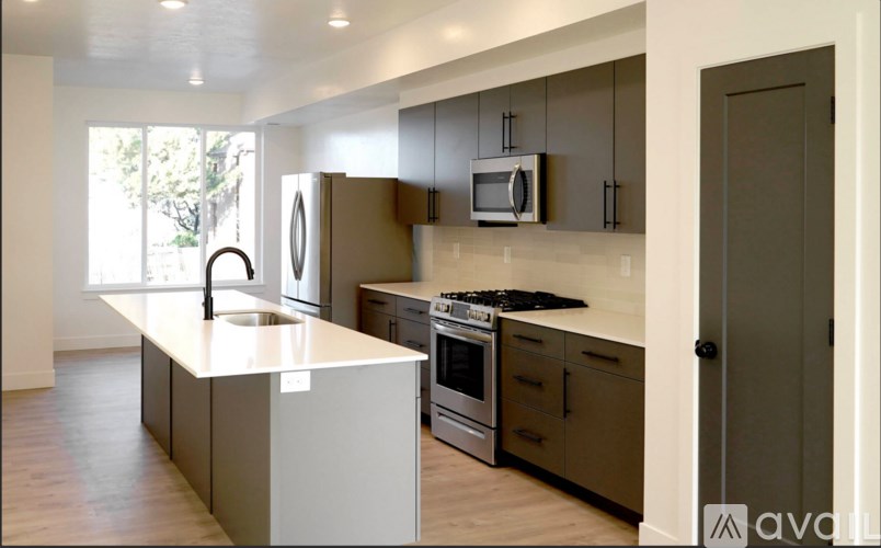 A modern kitchen with a white countertop and stainless steel appliances.