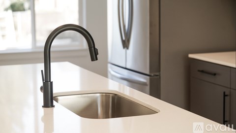 A modern kitchen with a sink and a refrigerator.