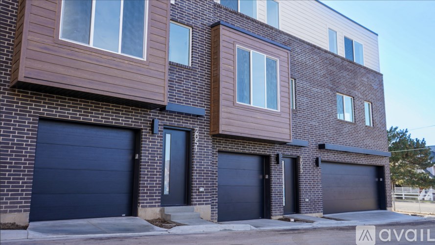 A modern house with a brown facade and three garages.