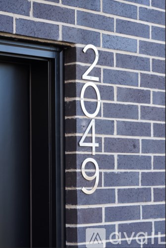 A number 2049 is written on a brick wall.
