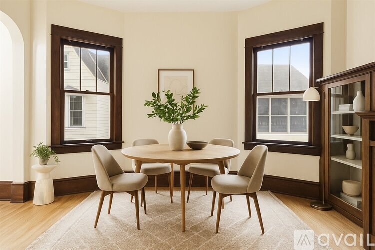 A dining room with a round table and chairs.