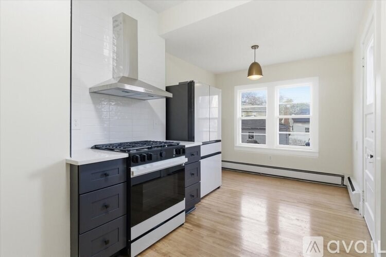 A kitchen with a black stove top oven and a black refrigerator.