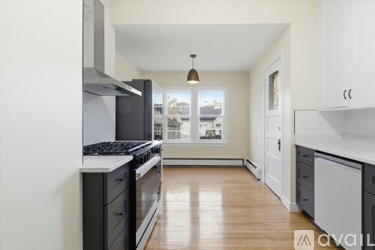 A kitchen with a stove top oven and a window.