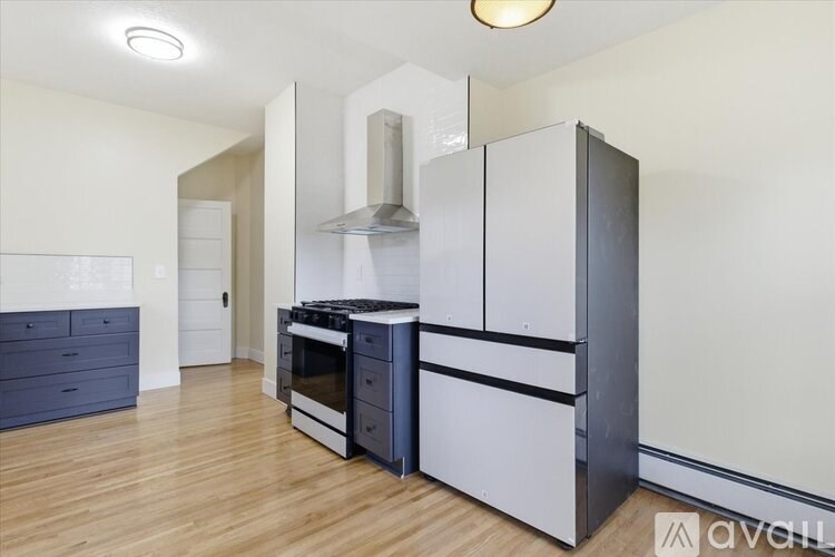 A modern kitchen with a stainless steel refrigerator and oven.
