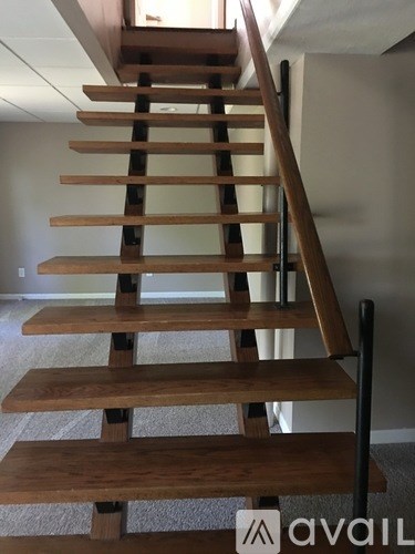 A wooden staircase with a metal handrail.