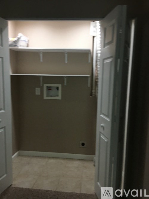 A small, dark room with a door open to a hallway.