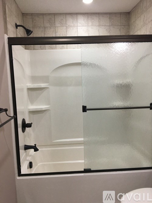 A glass shower door with a black frame.