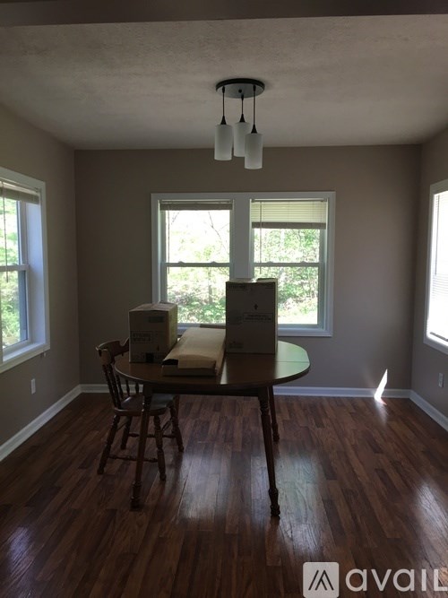 A room with a table and chairs and boxes on it.