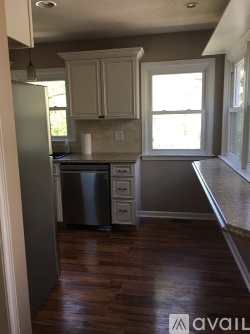 A kitchen with wooden floors and white cabinets.