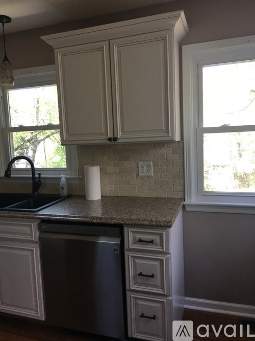 A kitchen with a granite countertop and white cabinets.