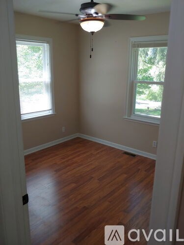 A room with wooden floors and a ceiling fan.