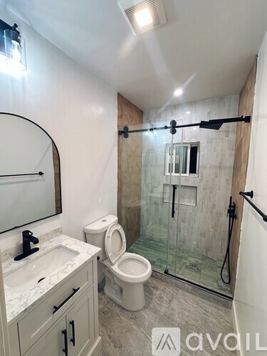 A bathroom with a toilet, sink, and shower.