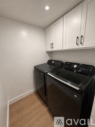 A black microwave oven and a black toaster oven are on a black countertop.
