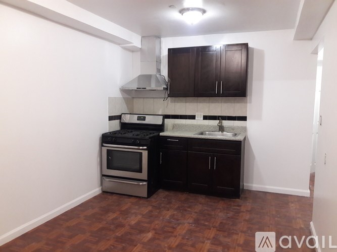 A kitchen with dark wood cabinets and a black stove top oven.