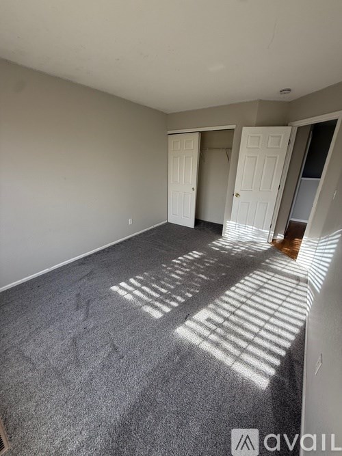 A room with a grey carpet and white walls.