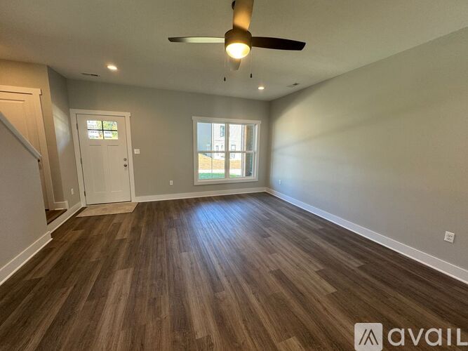 A room with wooden flooring and a ceiling fan.