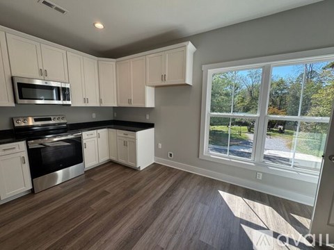 A kitchen with white cabinets and a black stove top oven.