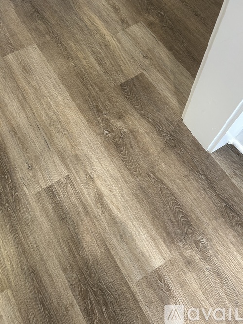 A wooden floor with a white wall on the side.