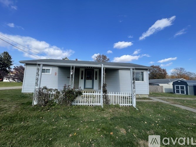A two-story house with a porch and a white picket fence.
