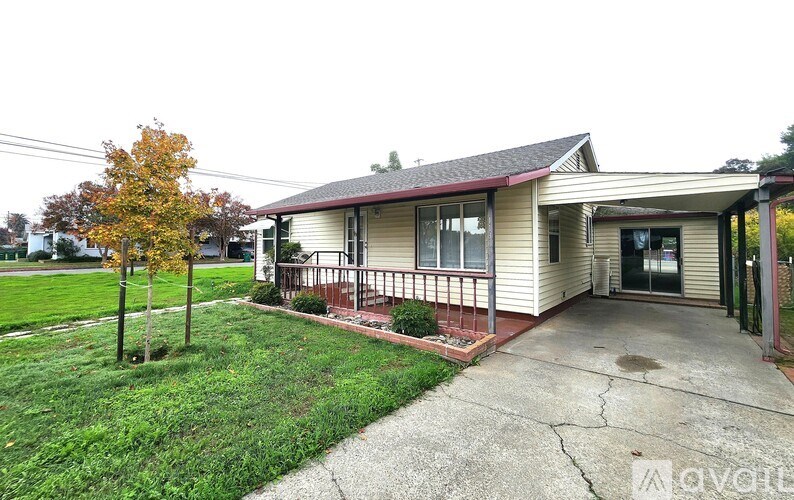 A house with a red roof and a porch.