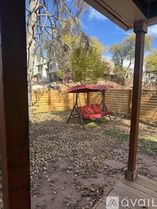A patio with a red chair and a table.