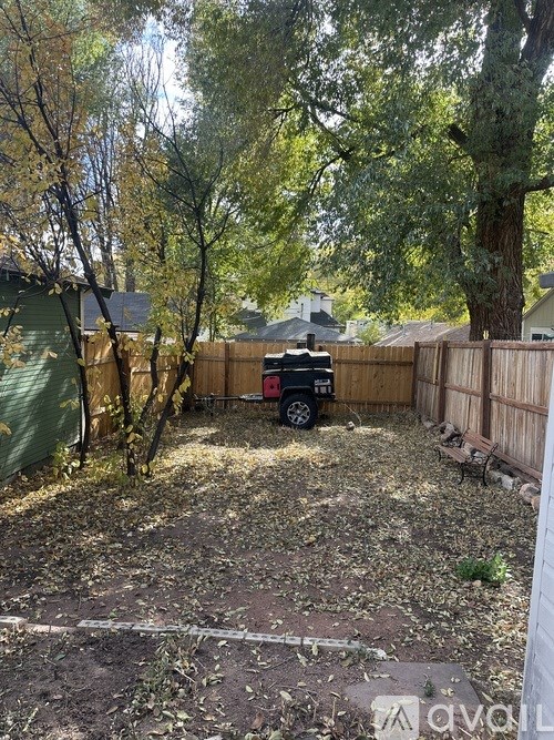 A backyard with a truck and a tree.