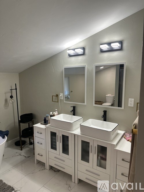 A bathroom with two sinks and a large mirror.