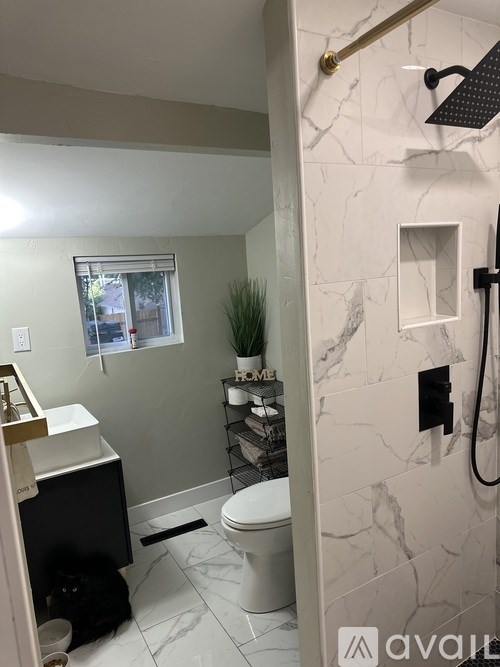 A bathroom with a toilet, sink, and a window.