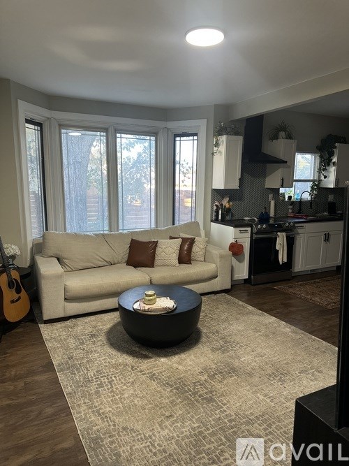 A living room with a couch, a coffee table, and a guitar.