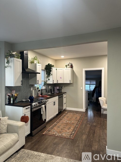 A kitchen with white cabinets and a black stove top oven.