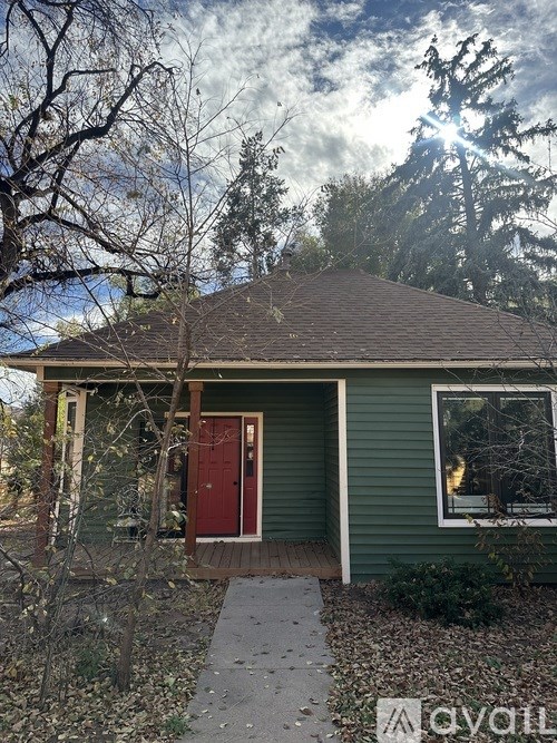 A small house with a red door and a green wall.