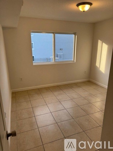A room with a tiled floor and a window overlooking a cityscape.