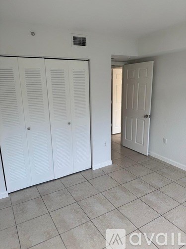 A room with white cabinets and a tiled floor.