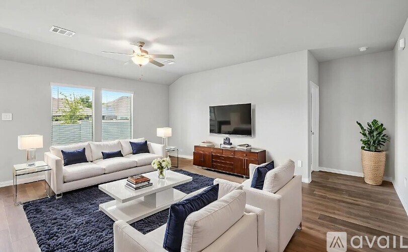 A living room with a white couch, a coffee table, and a ceiling fan.