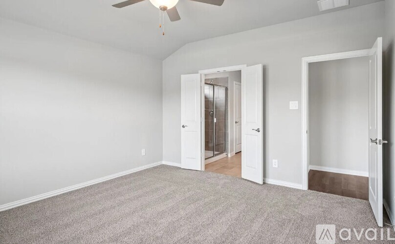 A room with a carpeted floor and a ceiling fan.