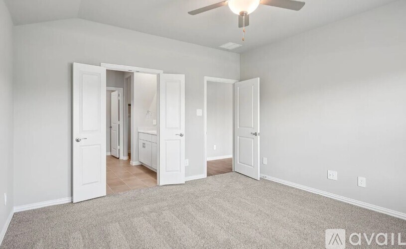 A room with a carpeted floor and a ceiling fan.