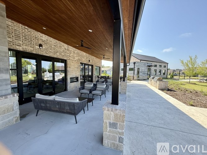 A patio area with a wooden ceiling and a stone wall.